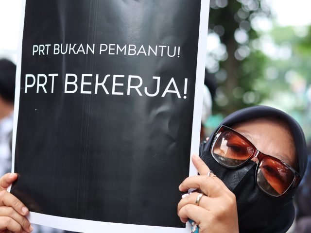 BUKAN PEMBANTU | Seorang massa aksi memegang poster bertuliskan “PRT BUKAN PEMBANTU, PRT BEKERJA”, Medan, Rabu (01/05). | Rachel Caroline L.Toruan