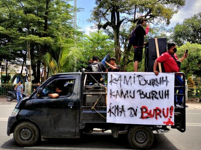 MEMULAI | Massa aksi Hari Buruh Internasional 2025 mulai beranjak dari titik kumpul. Sebuah spanduk bertuliskan "Kami Buruh, Kamu Buruh, Kita Diburu!" terpajang di atas kendaraan yang dinaiki para orator, Kamis (01/05/2025). | Tio Hasianna Vincentia Hutahaean