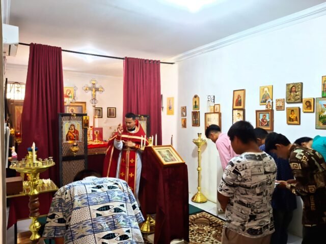 Jemaat menundukkan kepala saat menerima berkat dari Romo Nikola di Gereja Ortodoks Rusia dari Radonezh, Minggu (27/4/2025). | Derista Putri