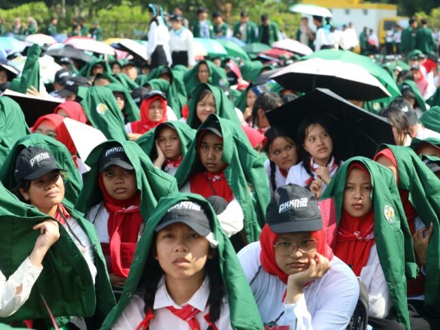 TERIK | Mahasiswa baru meneduhkan diri dengan almamater saat terik matahari pada PKKMB USU, Rabu (13/8/2025). | Dormaulina Sitanggang