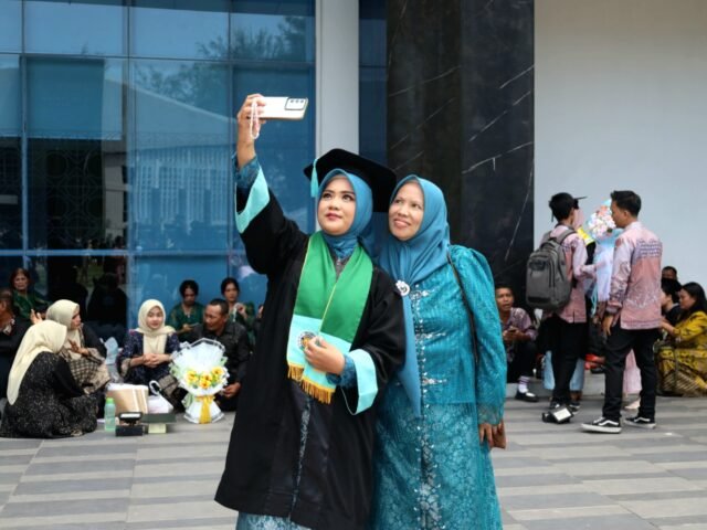 POTRET | Seorang wisudawati mengambil potret bersama ibunya. Keduanya tersenyum memandang kamera, menyimpulkan momen bahagia di hari wisuda, Jumat (29/8/2025). | Dinar Fazira Fitri