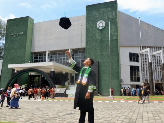 LEMPAR TOGA | Seorang wisudawan berfoto sambil melempar toga ke udara. Momen klasik sebagai simbol tuntasnya perjuangan menempuh pendidikan tinggi, Jumat (29/8/2025). | Imelda Sari Manalu