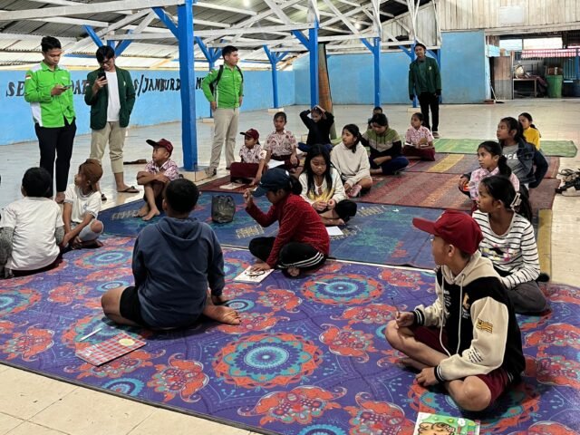 Anggota KKN-T KR 04 USU bersama anak-anak saat kegiatan Lomba Cerdas Cermat di Jambur, Desa Merdeka, Rabu (26/11/2025). | Sumber Istimewa