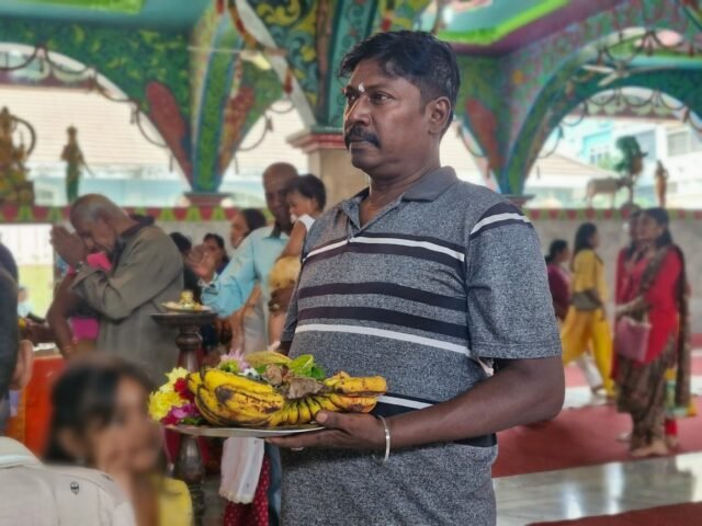 PERSEMBAHAN | Seorang umat Hindu sedang membawa persembahan untuk upacara bhajan Thaipusam, Minggu (1/2/2026). | Susy Simanungkalit