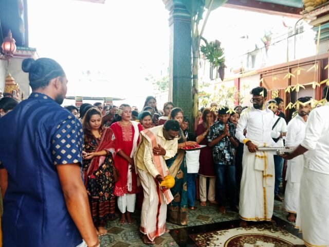 KUDUS | Seorang pujari memecahkan kelapa sebelum prosesi memasuki kuil, sebagai lambang pembersihan diri dan permohonan kelancaran ibadah, Minggu (1/2/2026). | Ruth Cinthia Sianturi