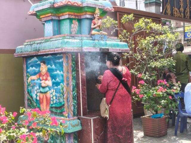 DOA | Seorang umat menyalakan dupa di depan kuil kecil. Asap dupa yang membumbung menjadi simbol penyampaian doa dan harapan, Minggu (1/2/2026). | Tio Hasianna Vincentia Hutahaean