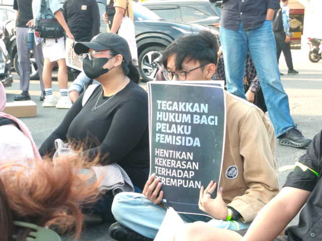 HENTIKAN | Peserta aksi duduk sambil membawa poster tuntutan untuk menghentikan kekerasan terhadap perempuan, Selasa (10/3/2026). | Tio Hasianna Vincentia Hutahaean