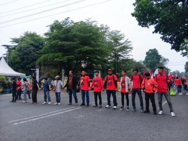 BERGANDENGAN | Massa aksi saling bergandengan tangan membentuk barisan. Aksi ini dilakukan sebagai simbol kekompakan sebelum kegiatan dimulai, Jumat (1/5/2026). | Imelda Sari Manalu