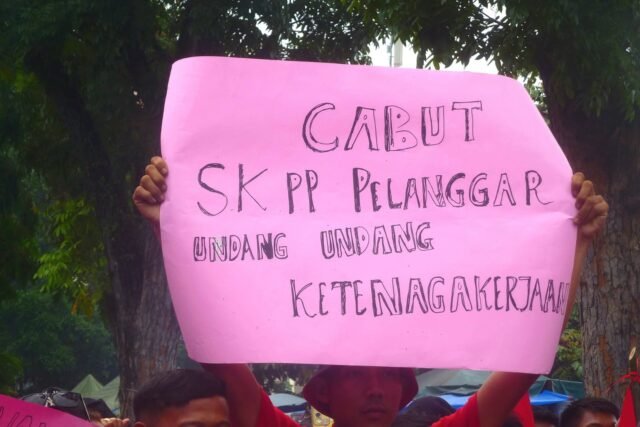 Angkat Tinggi I Seorang massa mengangkat poster yang menjadi medium penyampaian keluhan dan tuntutan dalam jalannya aksi, Jumat (1/5/2026). | Sepania Margareta Hutabarat