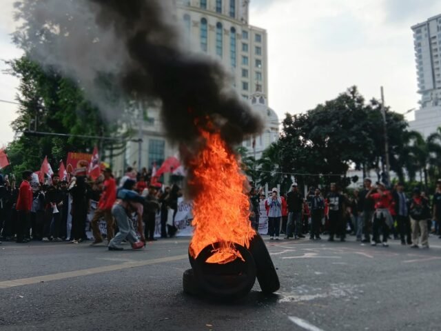 KOBARAN | Massa aksi membakar ban di tengah jalan depan Lapangan Merdeka. Kobaran api menjadi bentuk perlawanan atas tuntutan yang disampaikan, Jumat (1/5/2026). | Imelda Sari Manalu