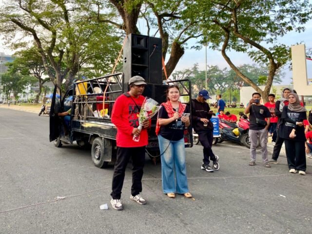PENUTUP | Seorang peserta aksi membawakan sebuah lagu sebagai penutup rangkaian peringatan Hari Buruh. Nyanyian tersebut menjadi seruan yang mengakhiri jalannya aksi, Jumat (1/5/2026). | Dwi Yolanda Naro Situmorang