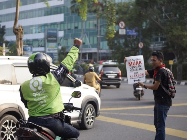 AKSI JALANAN | Aksi mahasiswa dengan poster kritik mendapat respons dari pengendara di tengah padatnya lalu lintas Kota Medan, Senin (15/6/2026). | Cyntia Lorena Br Tarigan
