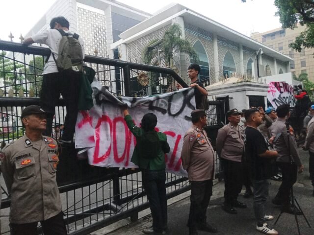 SPANDUK | Massa aksi bergerak memasang spanduk pada pagar gedung DPRD Sumut, Senin (15/6/2026). | Winny Stefanie
