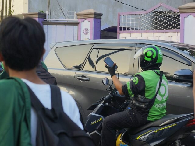 Pengemudi ojek online mengecek pesanan di tengah lalu lintas Kota Medan, Senin (15/06/2026). | Cyntia Lorena Br Tarigan