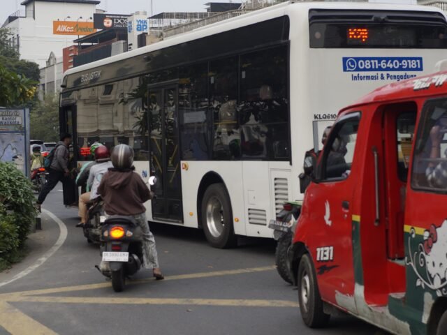 Angkot dan bus listrik melintas secara bersamaan di ruas jalan Kota Medan, Senin (15/06/2026). | Cyntia Lorena Br Tarigan