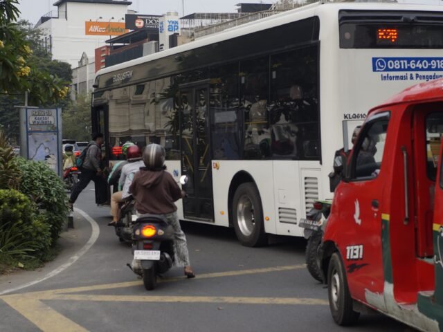 Angkot dan bus listrik melintas secara bersamaan di ruas jalan Kota Medan, Senin (15/06/2026). | Cyntia Lorena Br Tarigan