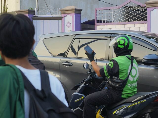 Pengemudi ojek online mengecek pesanan di tengah lalu lintas Kota Medan, Senin (15/6/2026). | Cyntia Lorena Br Tarigan
